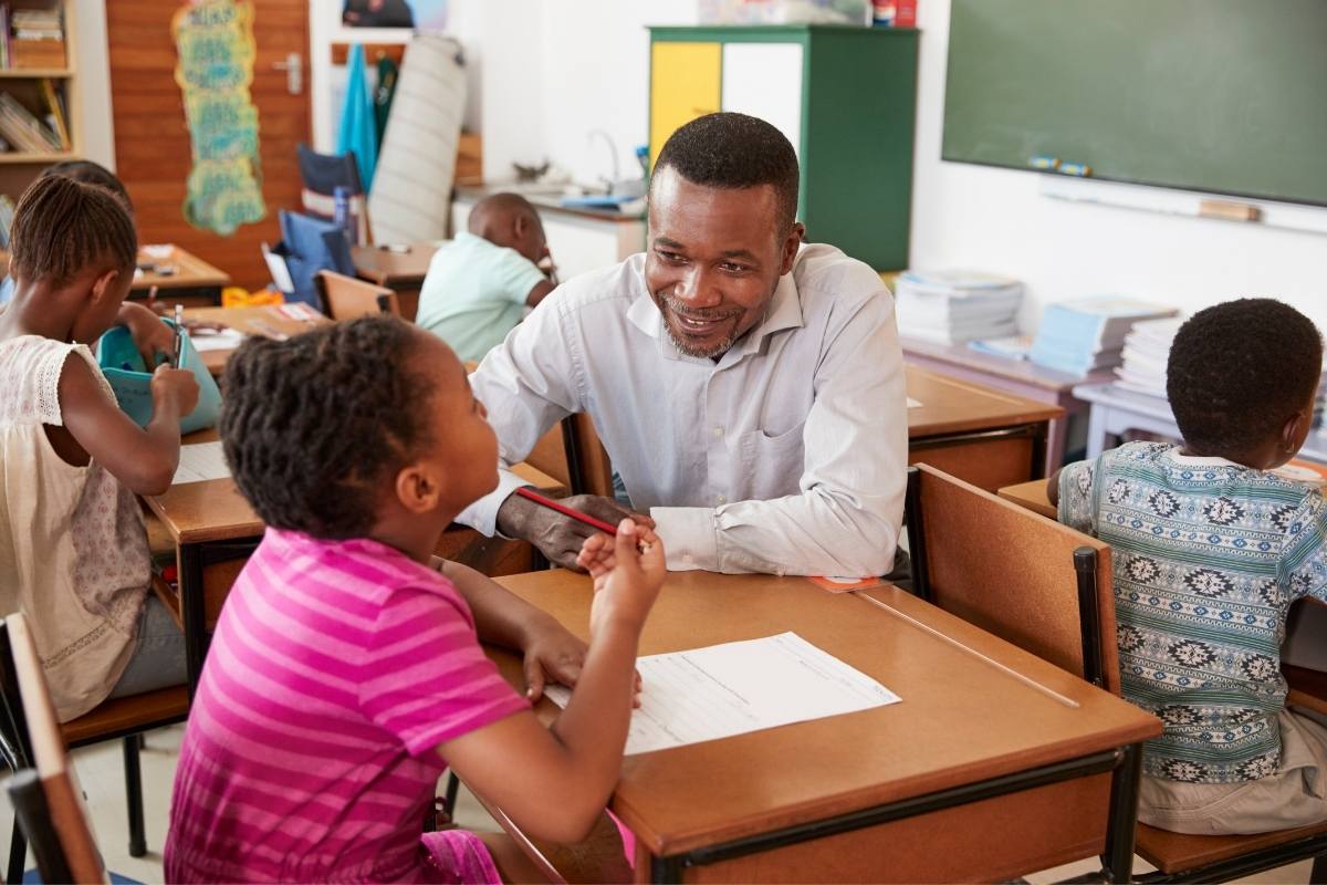 Black Male Teacher Helping Elementary School Girl Teacher Helping Elementary School Girl